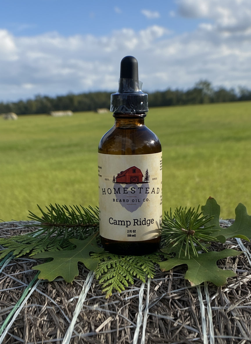 Bottle of Homestead Beard Oil Co. Camp Ridge on a hay bale with a field and trees in the background