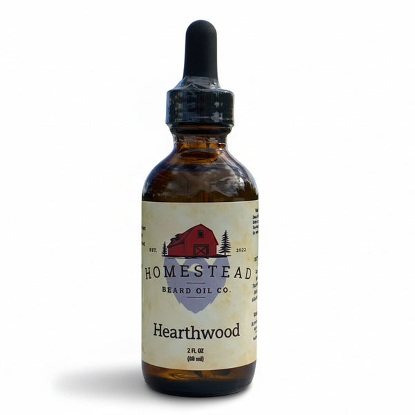 Bottle of Homestead Beard Oil Co. Hearthwood oil on a hay bale with a field and sky in the background