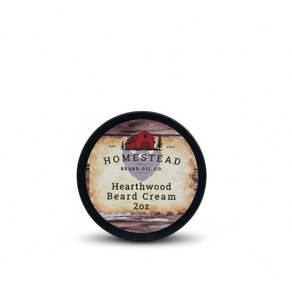 Homestead Beard Co. Hearthwood Beard Cream container on a grassy field with a cloudy sky.