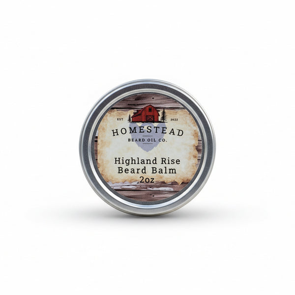 Homestead Beard Oil Co. Highland Rise Beard Balm container on grass with a field and trees in the background
