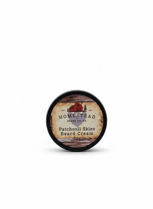 Homestead Brand Oil Co. patchouli skies beard cream container on a hay bale with a blue sky background